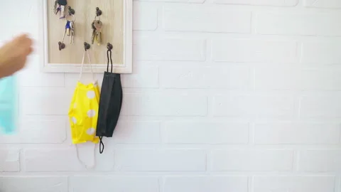 4K Female hinging the protective face mask and keys on organizer hook  Stock-Footage 148431526