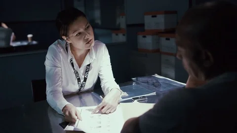 4K Female police detective questioning a crime suspect in interrogation room Stock Footage