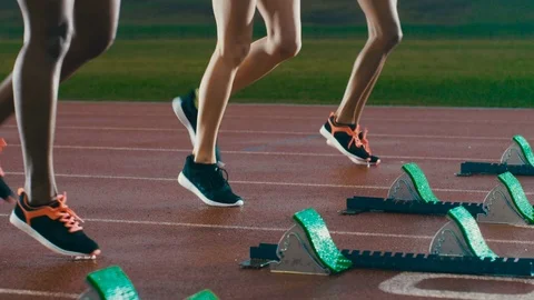4K Female runners at athletics track crouching at starting blocks before a race Stock Footage