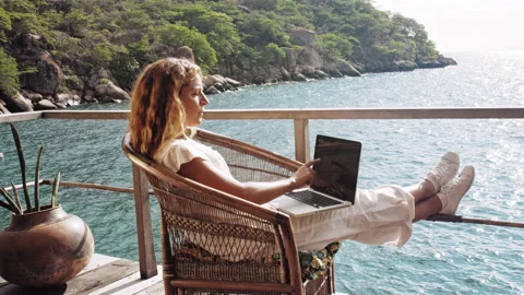 4k of Female working on laptop computer, touch screen technology on balcony of b Stock Footage 199626832