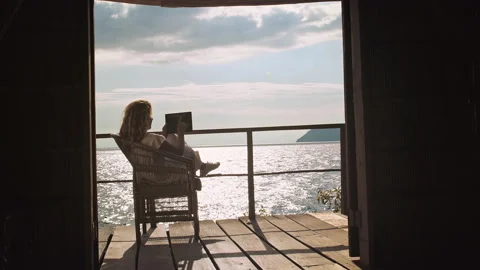 4k of Female working on touch screen tablet computer on balcony of bungalow. Stock Footage 199627018