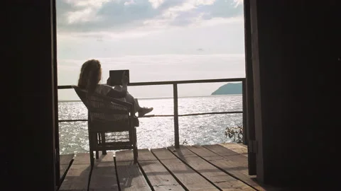 4k of Female working on touch screen tablet computer on balcony of bungalow. Suc Stock-Footage 199627034