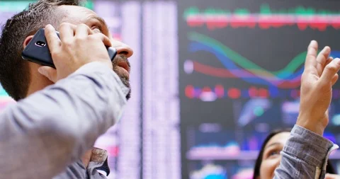 4K Financial traders gesturing with hands doing deals on phone at stock exchange Video stock 118877290