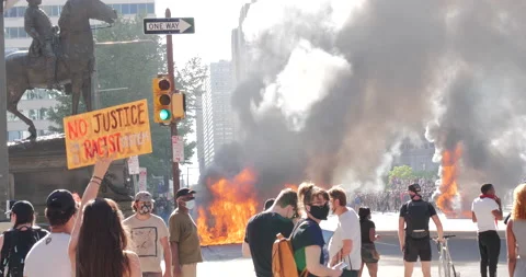 4K FIRE BURNING WITH PROTESTER HOLDING SIGN Stock Footage 131453497