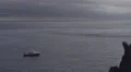 4K fishermans boat on calm ocean starts and drives away, cloudy sky 4k or 4k+ Resolution