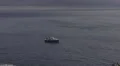 4K Fishing boat with men on, on blue sky-lined sea with waves lapping 4k or 4k+ Resolution