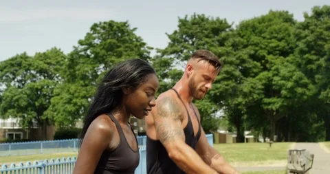4K Fit athletic couple working out in urban area, doing step ups onto park bench Video stock 94937991