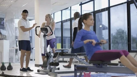 4K Fit group working out in the gym, video screen showing moving outdoor scene Stock Footage 75875401