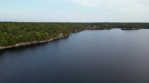 4K Flight Over The Clear Water Past The Rocky Shores, Airplane In The Sky Stock Footage 256942714
