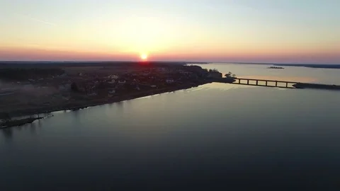 4K. Flight over large frozen lake with bridge in winter on sunset, aerial view. Video stock 82179838