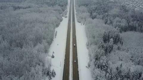 4K. Flight over road in winter forest with cars. Vanishing point perspective. 動画素材 84249525