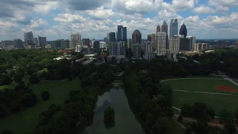 4k flight towards Mid town Atlanta skyline over Piedmont Park Stock Footage 78747863