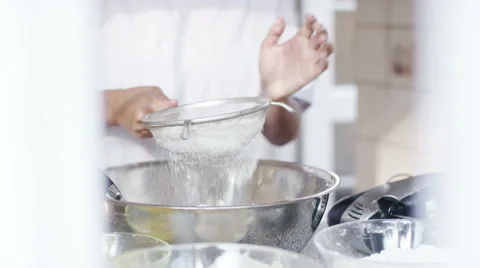 4K Flour being put through a sieve into a mixing bowl, in slow motion Free Stock Footage 56194701