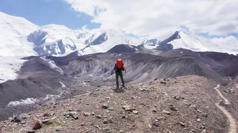 4K fly away drone video of lonely climber in mountaineering gear with backpack a Stock-Footage 325214619