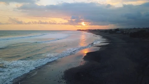 4K Fly over volcanic black sand beach at sunset Stock Footage 115508195