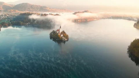 4K Flying around romantic Bled lake with chapel on the island at foggy sunrise Stock Footage 100821508