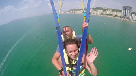 4k Flying fun couple on parachute flight Stock Footage 56028845