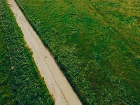 4k flying Over Green Field with Dirt Road with LUT Stock Footage 74112432
