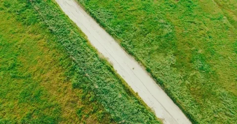 4k flying Over Green Field with Dirt Road long clip with LUT Stock Footage 74112752