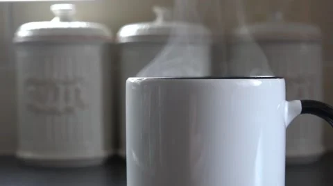 4k focus pull on hot steamy coffee with jar in the background Stock Footage 47371791