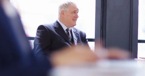 4K Focus pull from senior businessman in a meeting to hands typing on laptop Stock Footage 104122355