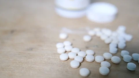4K Focus pull on white vitamin pain killers pills on wooden surface Stock Footage 90176561