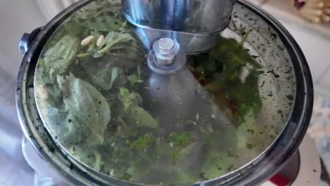 4K footage of a blender grinding basil and pine nuts in slow motion Stock Footage 345647367