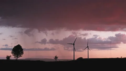 4k footage of clouds at sunset over a field with wind turbines to generate Stock Footage 235203458