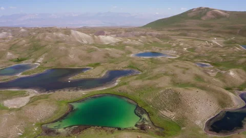 4K footage of Slow flying drone over majestic green lake with unique curved shap Video stock 340096516