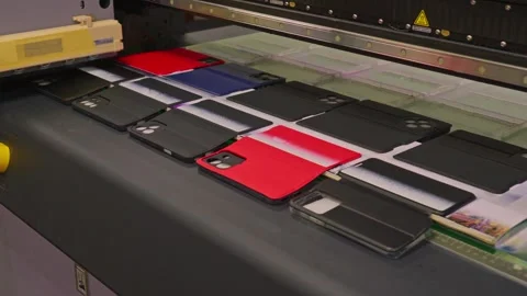 4K footage of a UV flatbed printer  printing an image on ten mobile phone case. Stock Footage 328494054