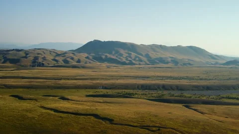 4K forward drone flight over yellow plain towards distant mountains Stock Footage 315195275