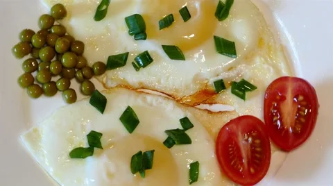 4k fried eggs with tomatoes, spring onion and peas (close up) Stock Footage 49674920