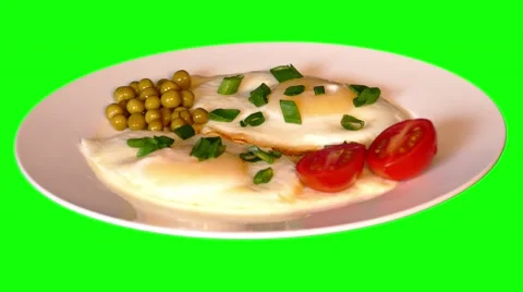 4k fried eggs with tomatoes, spring onion and peas on plate Stock Footage 50000608