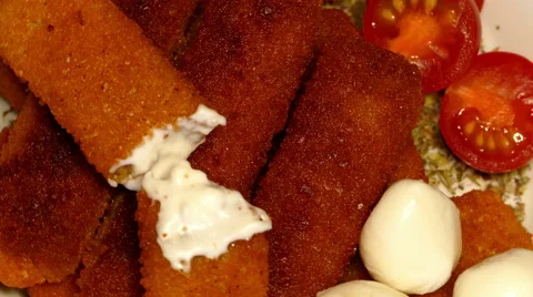 4k – Fried fish sticks with cherry tomatoes and mozzarella balls on plate 01 Stock Footage 56162869