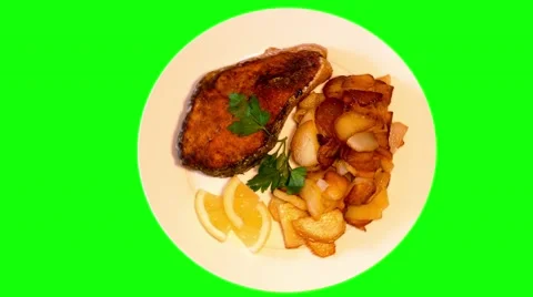 4k fried potatoes with grilled fish and lemon on plate Stock Footage 49664321