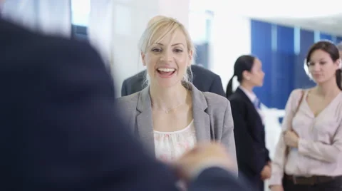 4K Friendly bank worker assisting queue of customers with enquiries Stock Footage 64257230