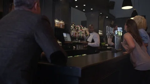 4K Friendly Bar Staff Serving Young Fun Crowd In Fashionable City Bar Stock Footage 75635169