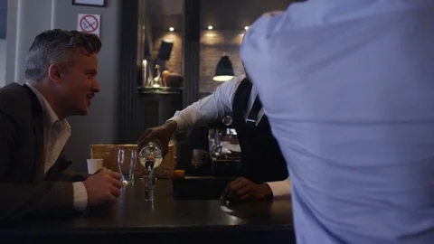 4K Friendly Bar Staff Serving Young Fun Crowd In Fashionable City Bar Stock Footage 75637391