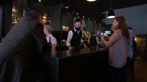 4K Friendly Barman Serving In Bar &amp; Taking Photo Of Group Of Girls On Night Out Video stock 75639145