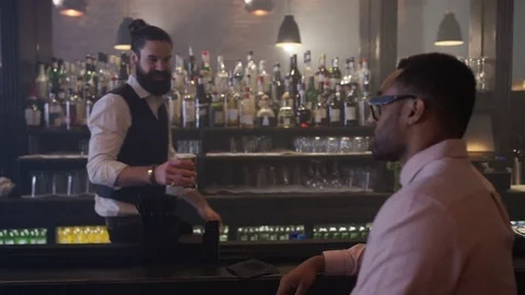 4K Friendly Bartender Serving &amp; Chatting With Customer In Trendy Bar Stock Footage 75609717