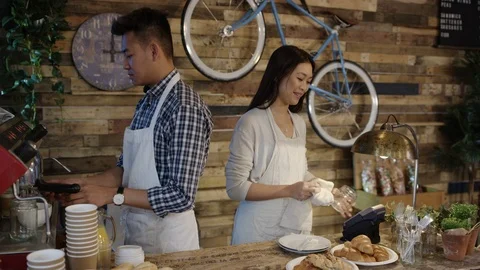 4K Friendly cafe owner couple serving customer &amp; taking contactless payment Stock Footage 76610403