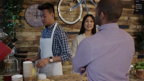 4K Friendly cafe owner couple serving customer &amp; taking contactless payment Stock Footage 76611989