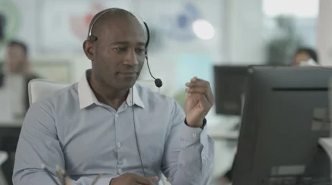 4K Friendly customer service operator talking to customer in busy call centre Stock Footage 64576209