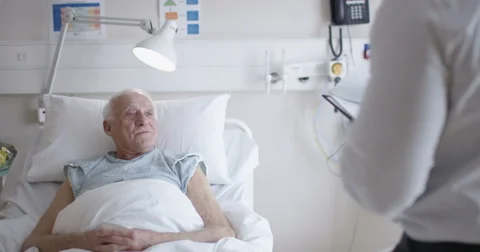 4K Friendly doctor talking to elderly patient at his bedside Stock Footage 62981706