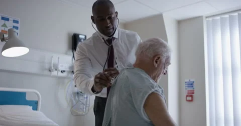 4K Friendly hospital doctor examining elderly patient in a private room Stock Footage
