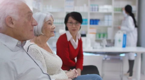 4K Friendly pharmacy worker gives prescription medication to customer Stock Footage