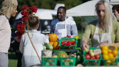 4K Friendly stall holders selling fresh produce to customers at farmers market Vidéo 72609898
