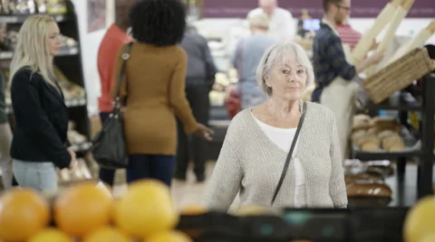 4K Friendly worker in a supermarket assisting senior lady buying groceries Stock Footage 67757946