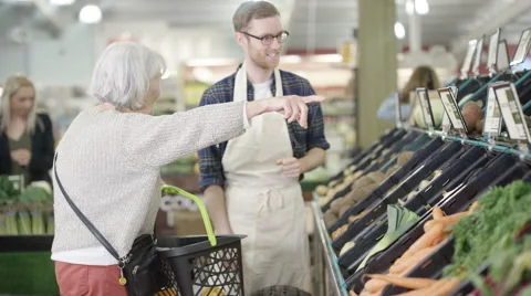 4K Friendly worker in a supermarket assisting senior lady buying groceries Stock Footage 67848224