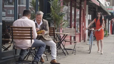 4K Friends With Computer Tablet At Cafe Table Stare As Attractive Woman Walks By Stock Footage 75736819